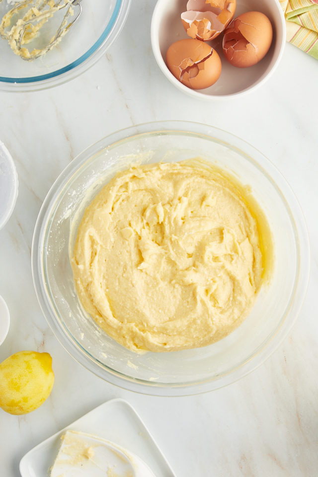 overhead view of lemon ricotta cake batter in a glass mixing bowl