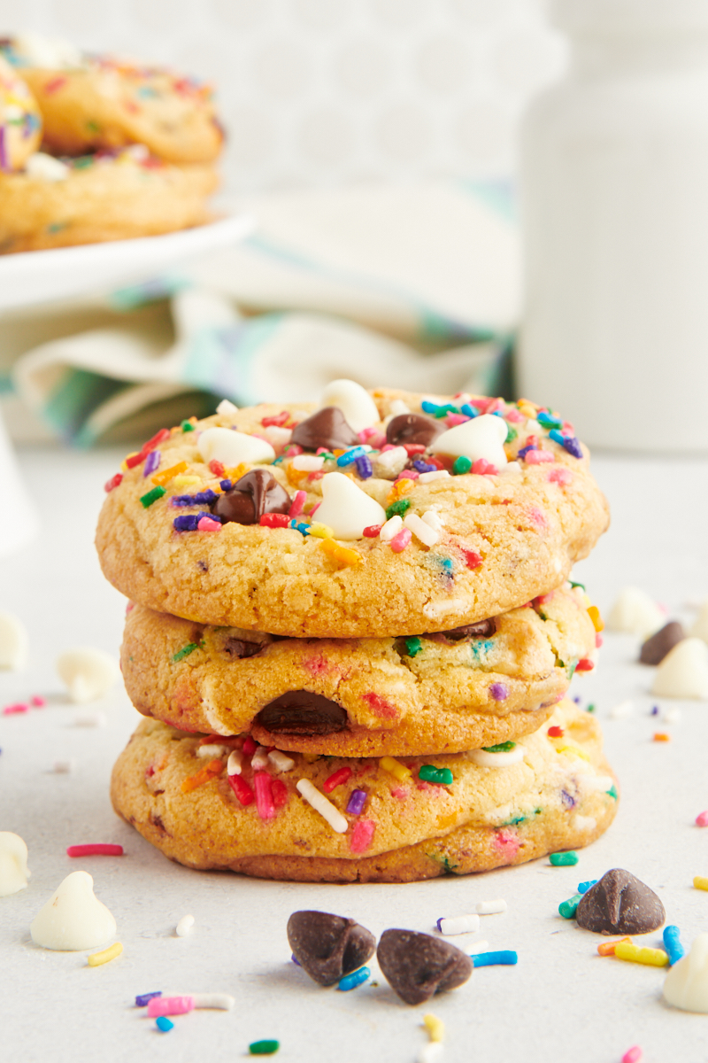 a stack of three sprinkle chocolate chip cookies on a white countertop