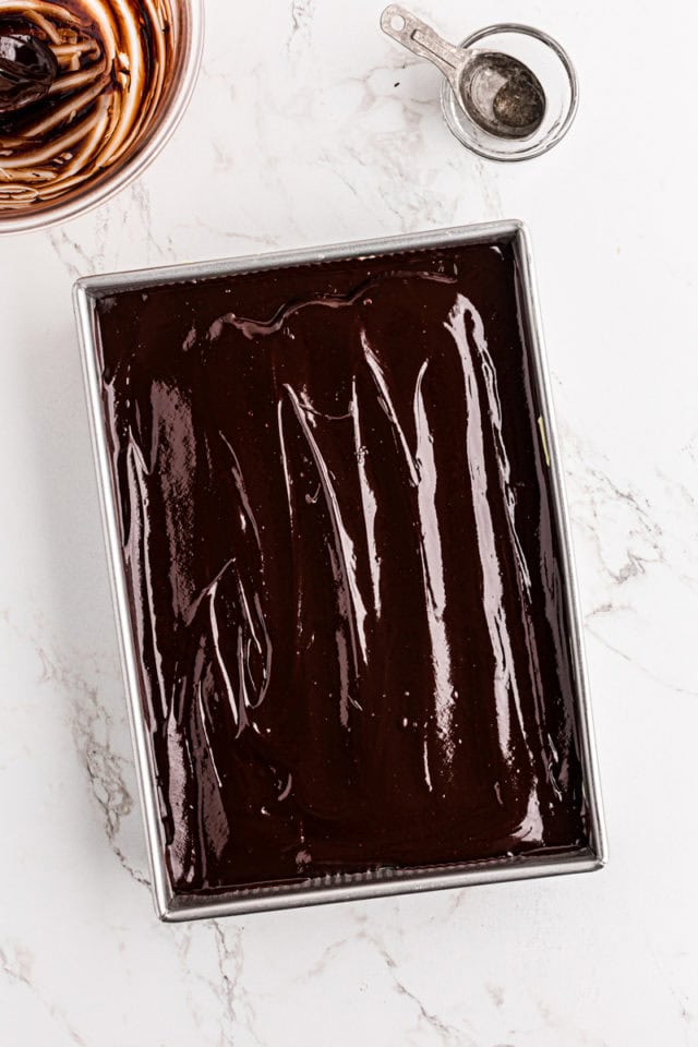 overhead view of chocolate ganache spread over chocolate eclair cake