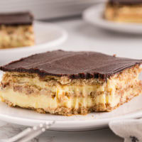 a slice of chocolate eclair cake with a bite missing from the front corner