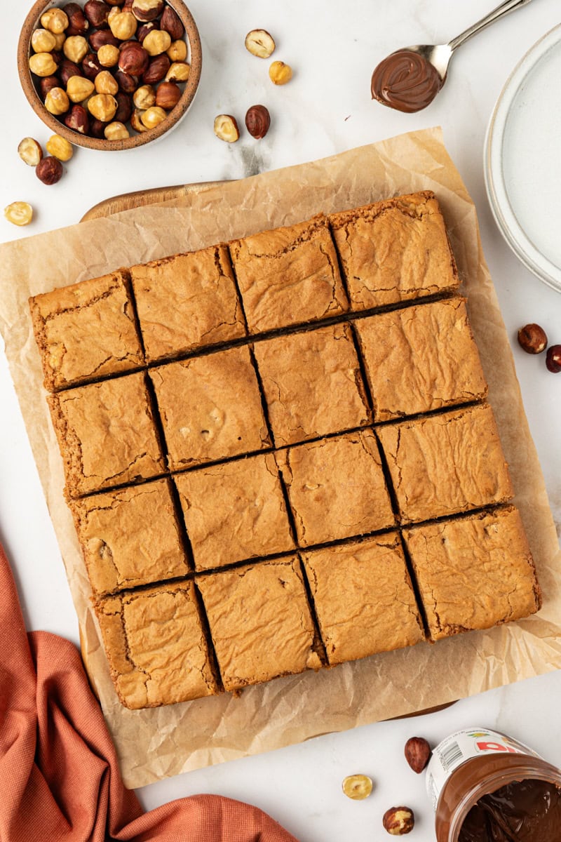overhead view of sliced hazelnut blondies on parchment paper