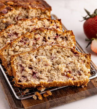 sliced strawberry cream cheese bread on a wooden cutting board