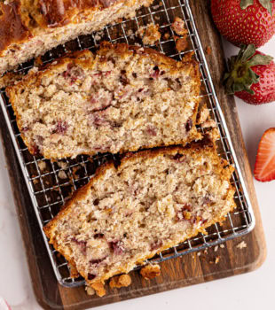 overhead view of sliced strawberry cream cheese bread on a wooden cutting board