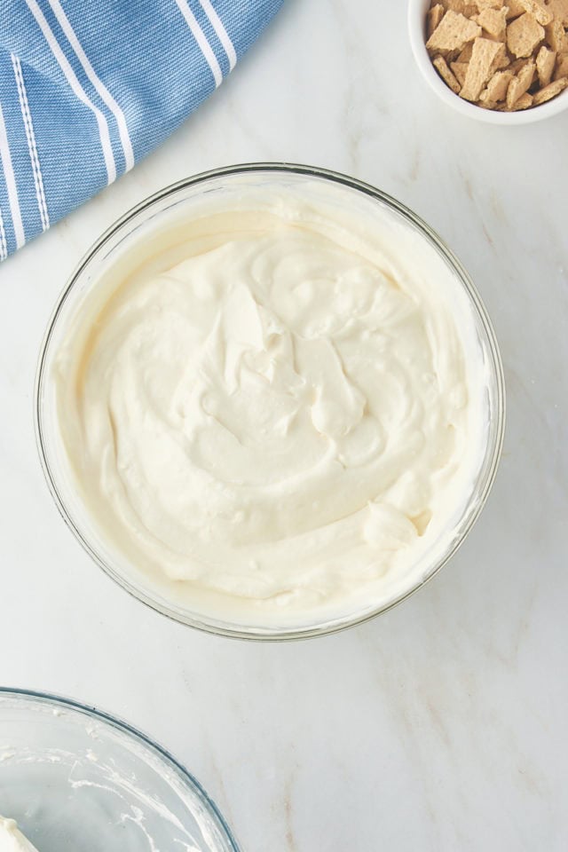 overhead view of mixed cream cheese ice cream in a glass mixing bowl