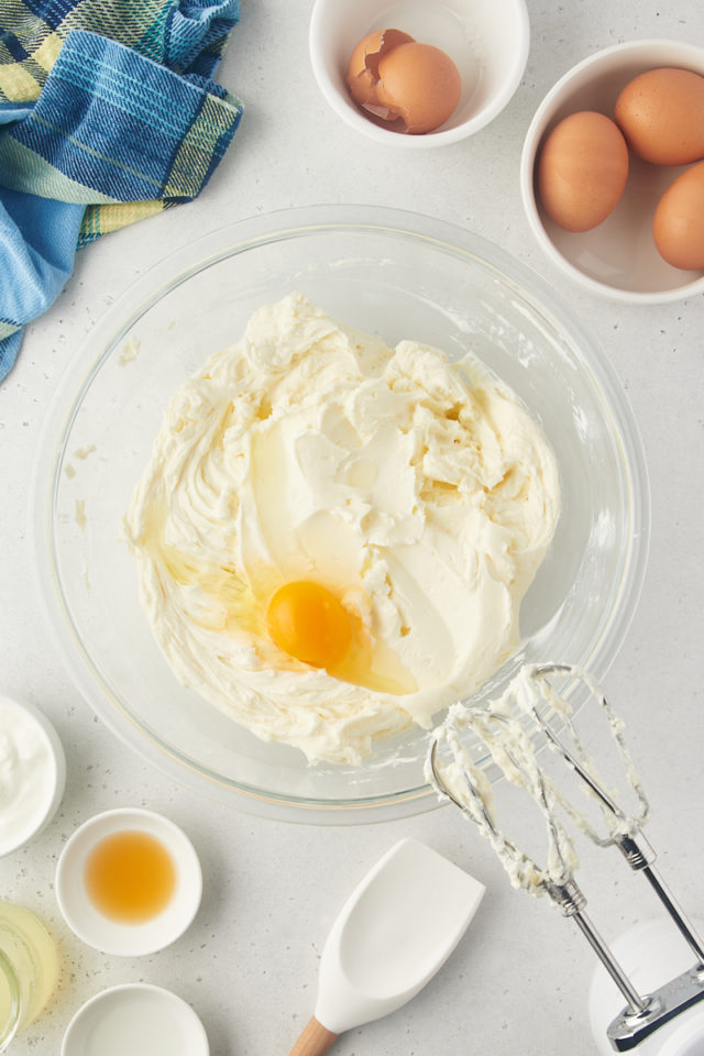 overhead view of egg added to cream cheese mixture for lemon cheesecake