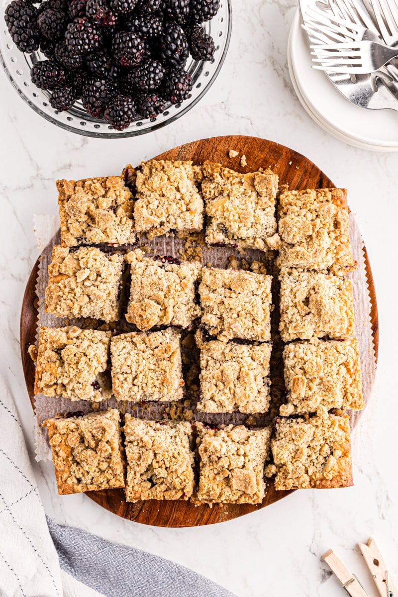 overhead view of sliced blackberry crumb bars on a wooden cutting board