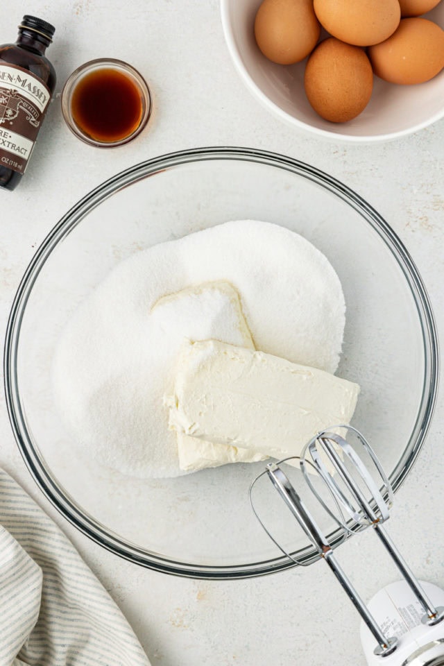 overhead view of cream cheese and sugar in a glass mixing bowl