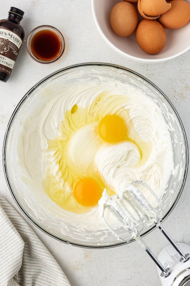 overhead view of eggs added to beaten cream cheese and sugar