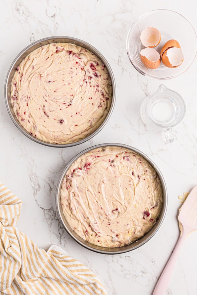 overhead view of lemon raspberry cake batter divided between two round cake pans