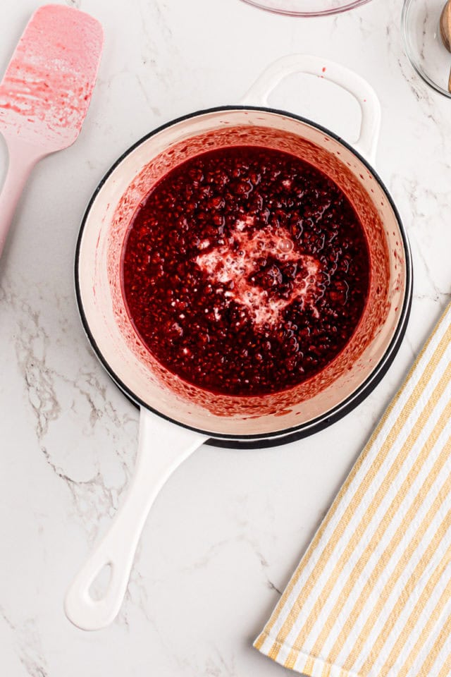 overhead view of cornstarch slurry added to cooked raspberries