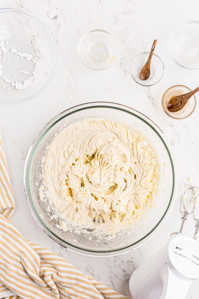 overhead view of lemon frosting in a glass mixing bowl