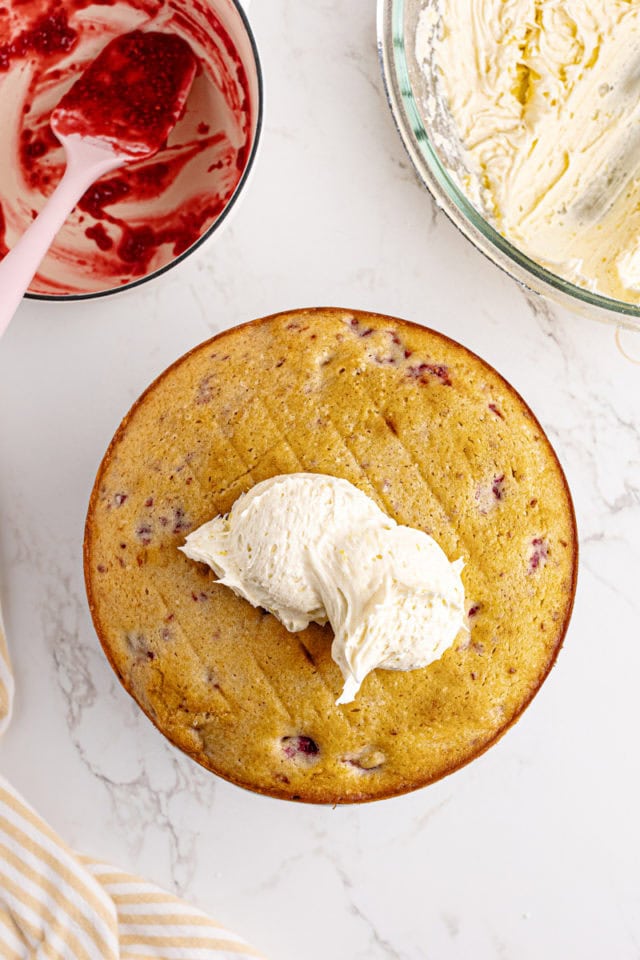 overhead view of lemon frosting on top of lemon raspberry cake