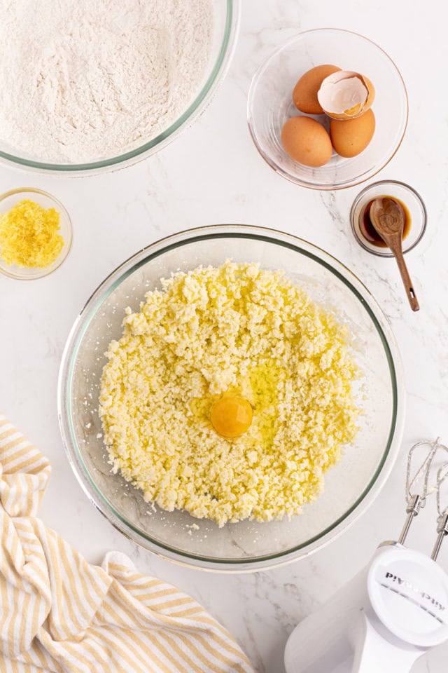 overhead view of egg added to creamed butter and sugar