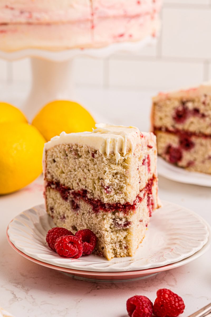 a slice of lemon raspberry cake with a bite missing from the front