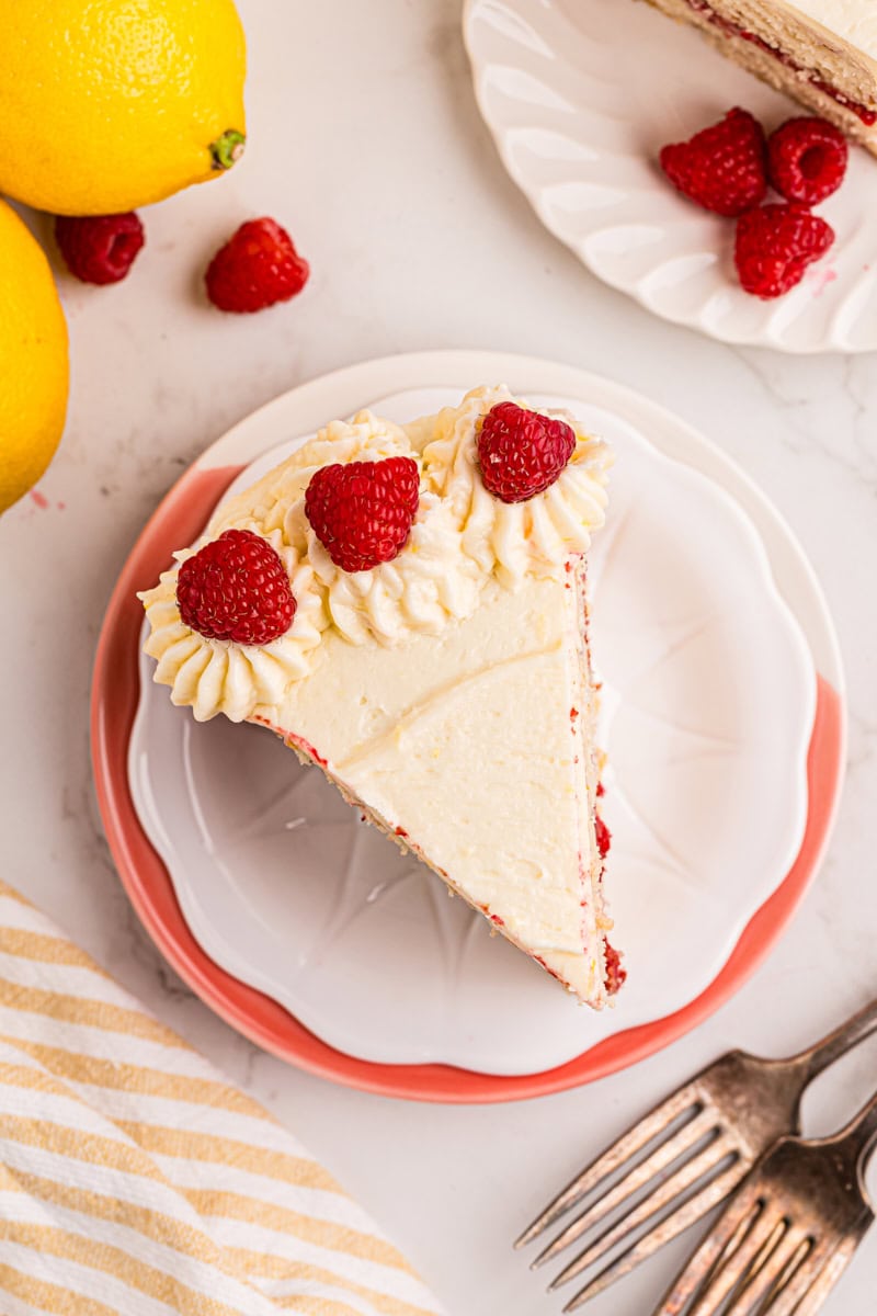 overhead view of a slice of lemon raspberry cake on a white plate