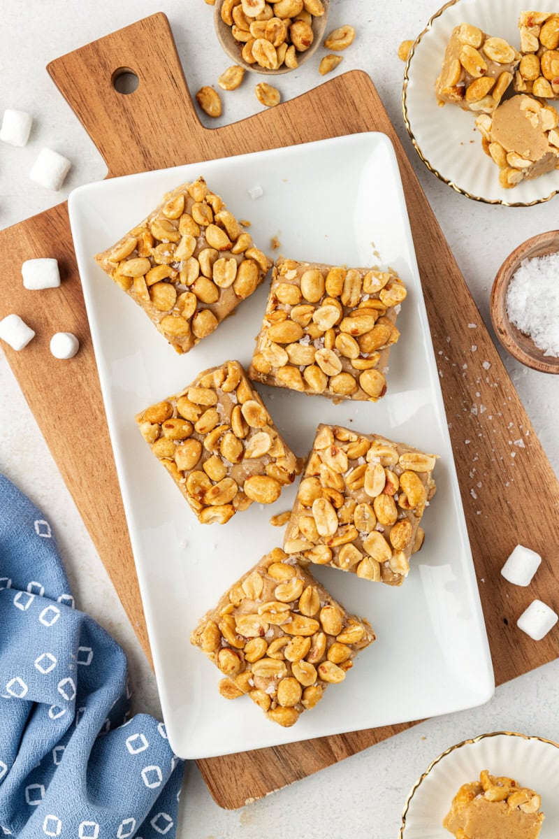 overhead view of five salted nut squares on a white tray sitting on a wooden cutting board