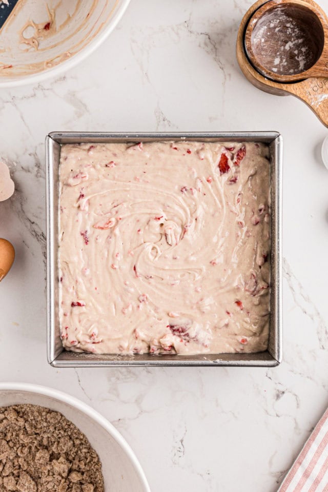 overhead view of strawberry coffee cake batter spread in a rectangular baking pan