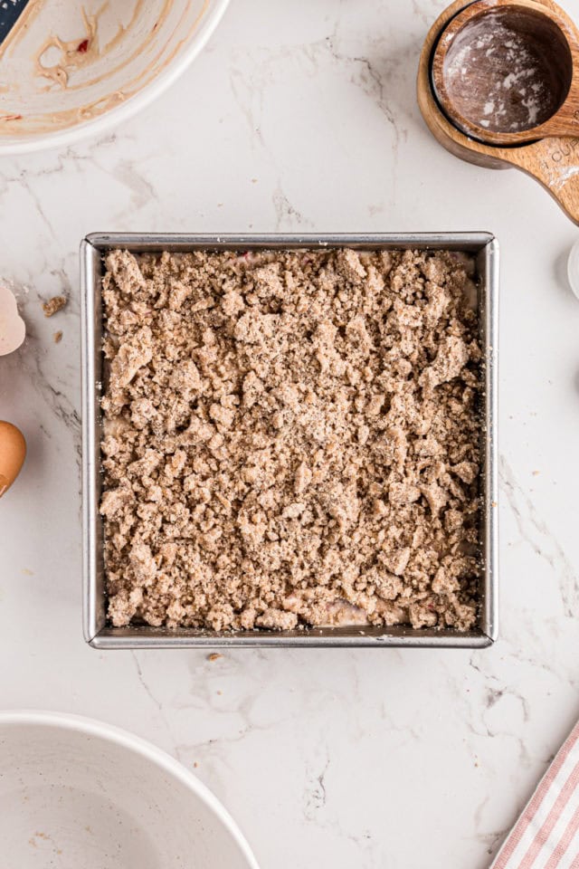 overhead view of strawberry coffee cake topped with crumb topping ready to go into the oven