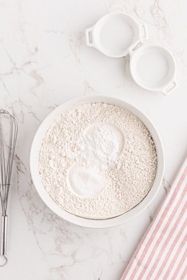 overhead view of flour, baking powder, and salt in a white mixing bowl