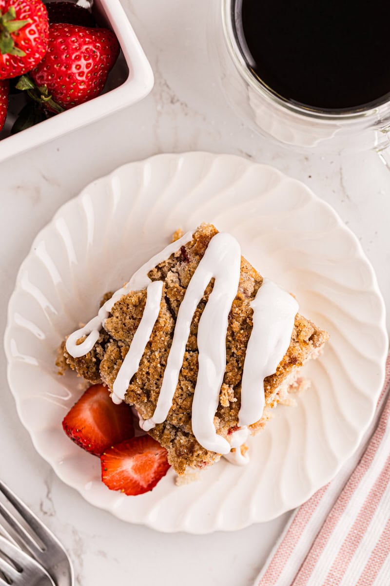 overhead view of a slice of strawberry coffee cake topped with a simple glaze