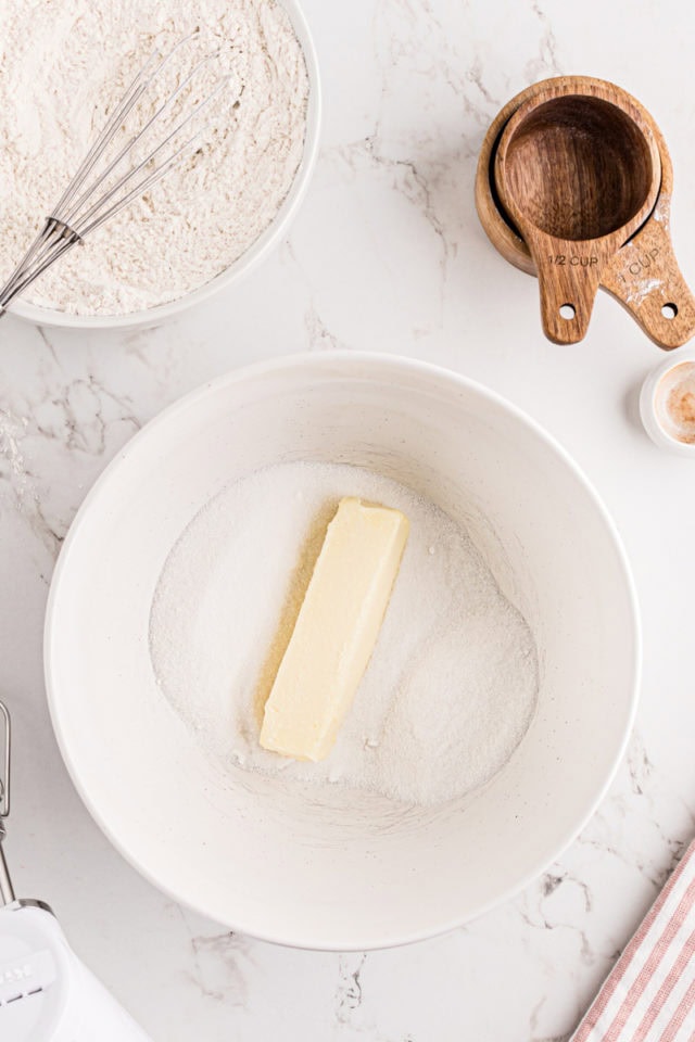 overhead view of butter and sugar in a white mixing bowl