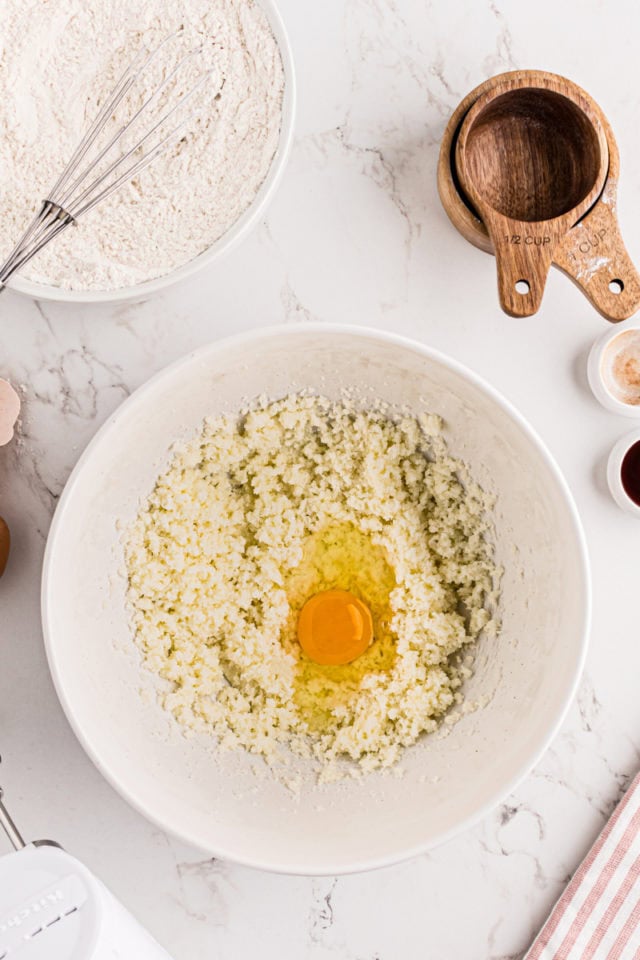 overhead view of egg added to creamed butter and sugar