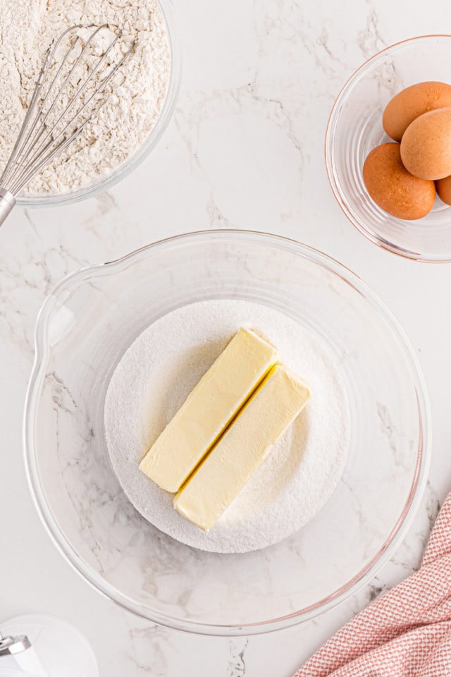 overhead view of sugar and butter in a glass mixing bowl