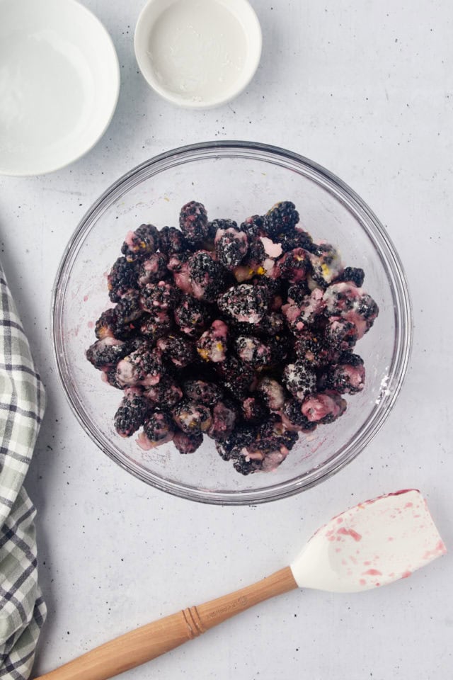 overhead view of blackberry cobbler filling in a glass mixing bowl