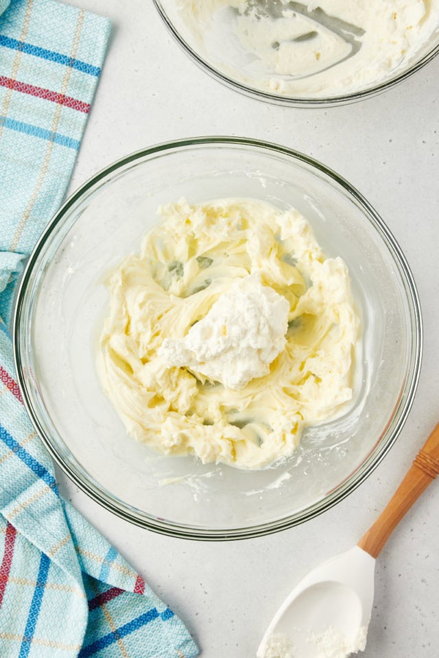 overhead view of whipped cream added to remaining cheesecake ingredients