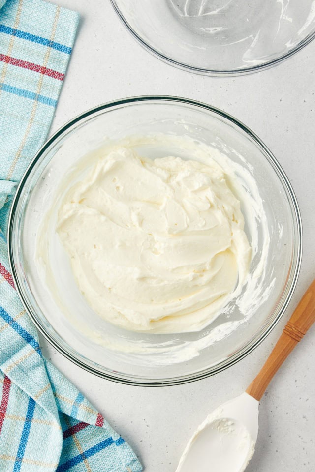 overhead view of mixed no-bake cheesecake filling in a glass mixing bowl