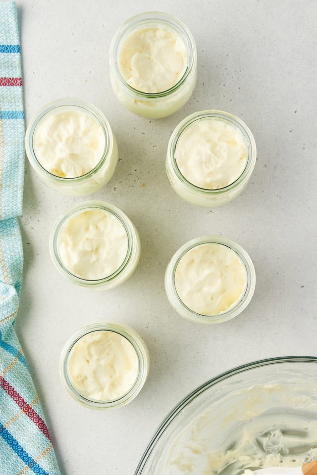 overhead view of no-bake cheesecake filling added to individual jars