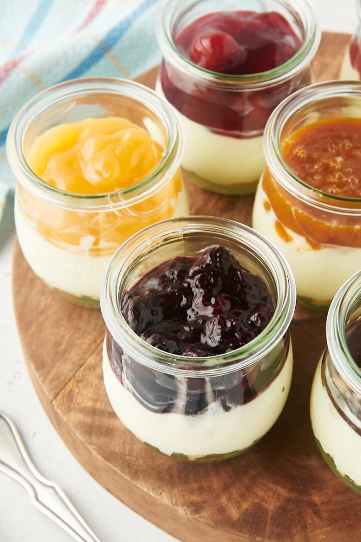 no-bake cheesecake jars on a round wooden serving board