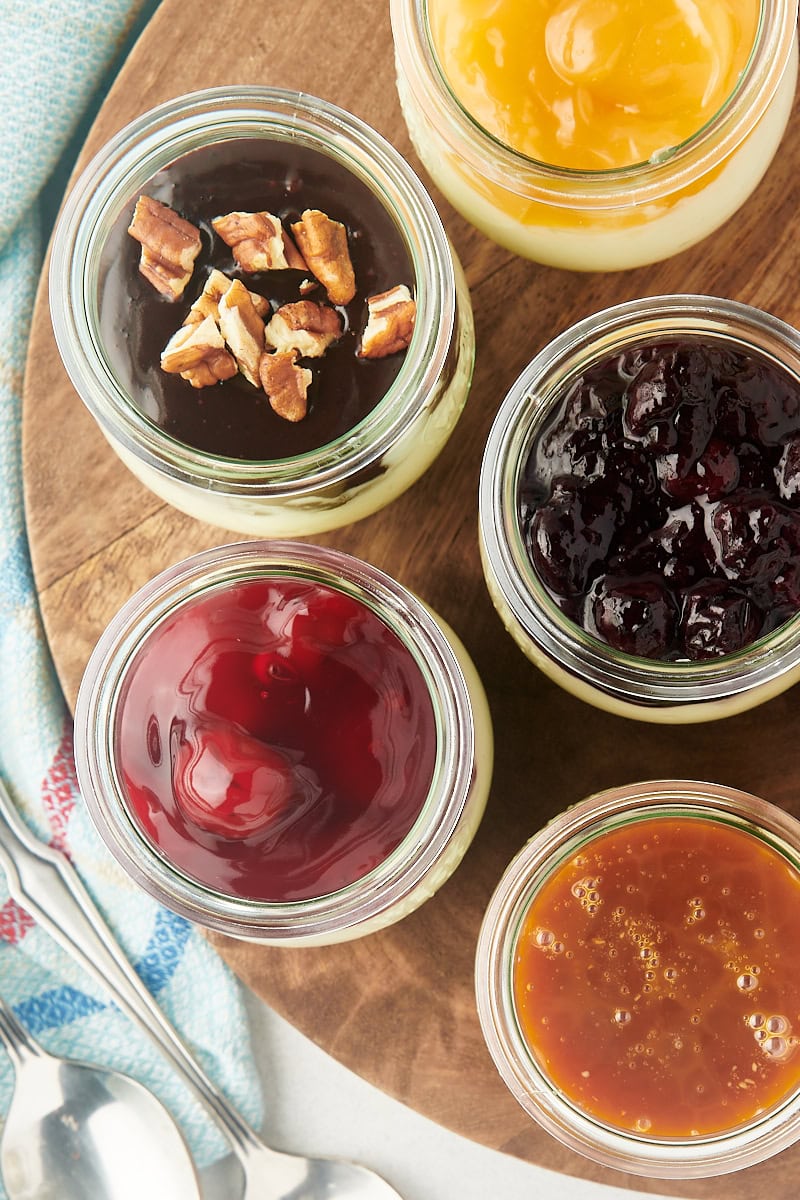 overhead view of no-bake cheesecake jars on a round wooden board