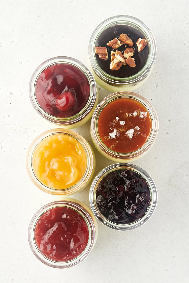 overhead view of six no-bake cheesecake jars with various toppings