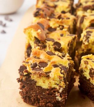 chocolate chip cheesecake brownies lined up on parchment paper