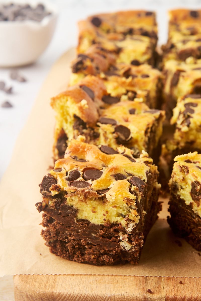 chocolate chip cheesecake brownies lined up on parchment paper