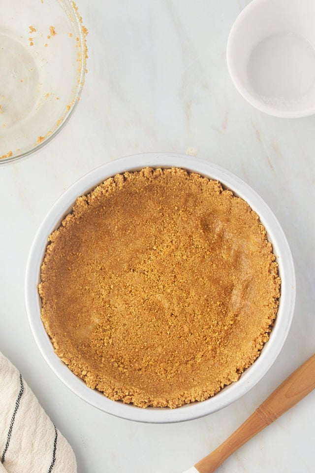 overhead view of graham cracker crust in a metal pie plate