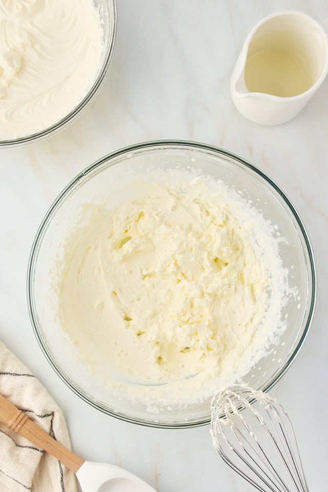 overhead view of whipped cream in a glass mixing bowl