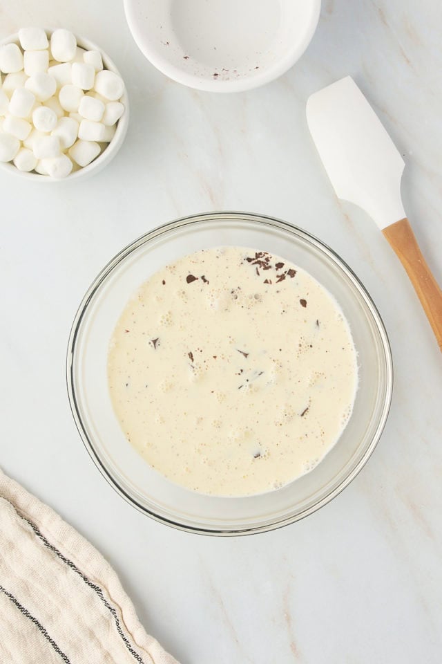 overhead view of chocolate and heated cream in a glass bowl