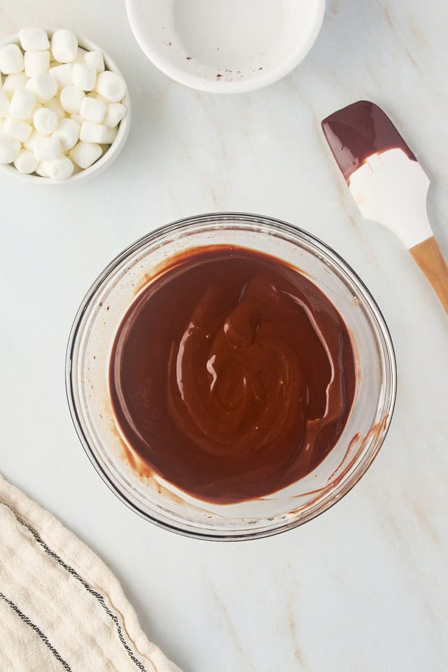 overhead view of chocolate ganache in a glass mixing bowl