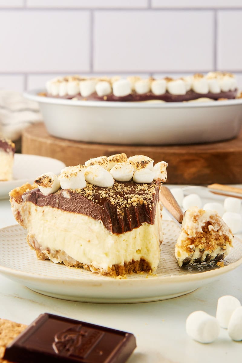 a slice of s'mores pie on a plate with a bite on a fork