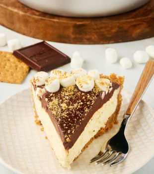 a slice of s'mores pie on a plate with the remaining pie in the background