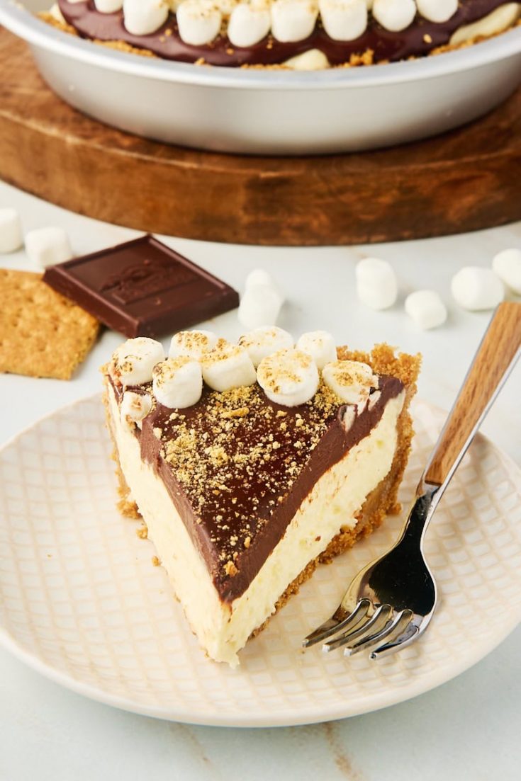 a slice of s'mores pie on a plate with the remaining pie in the background