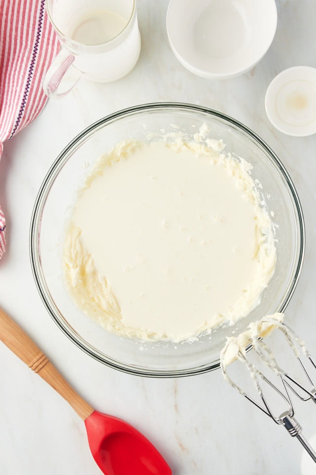 Overhead view of whipped cream in glass mixing bowl