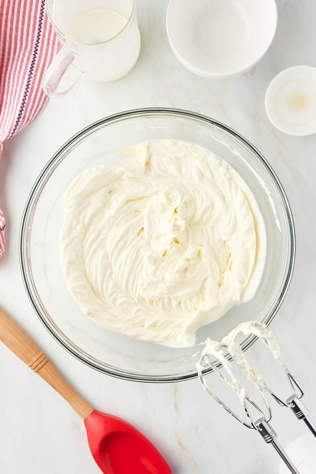 overhead view of whipped cream in a glass mixing bowl