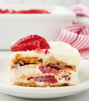 Side view of strawberry icebox cake on plate, showing layers