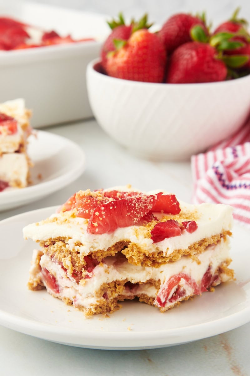 Slice of strawberry icebox cake on plate with corner eaten