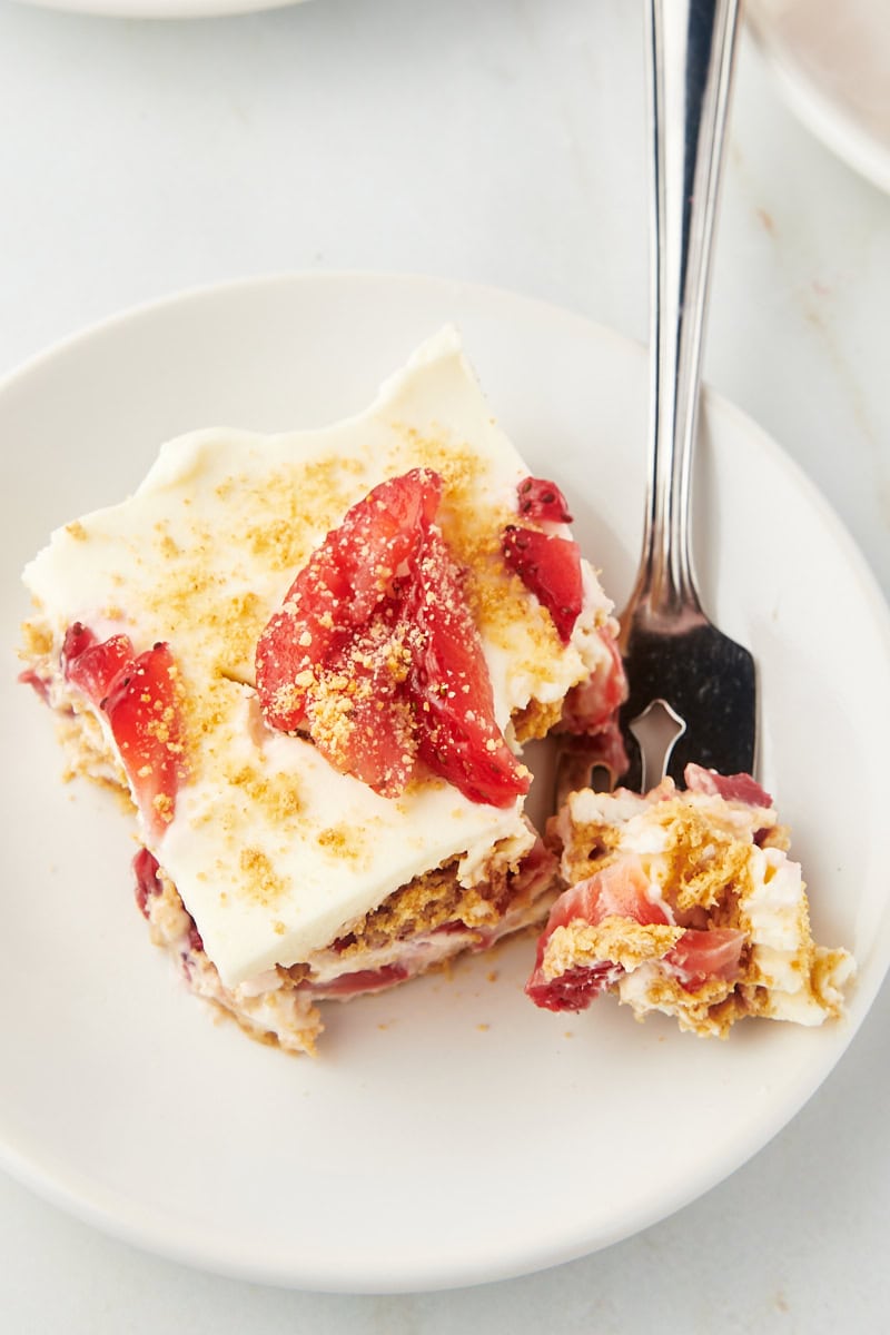 Top-down view of strawberry icebox cake slice on plate with fork