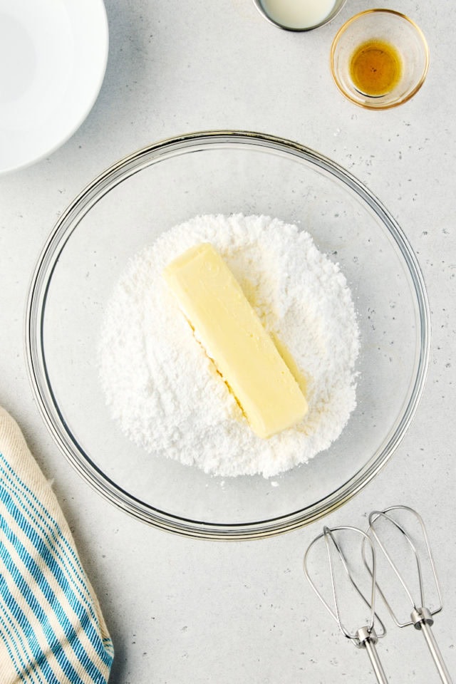 overhead view of confectioners' sugar and butter in a glass mixing bowl