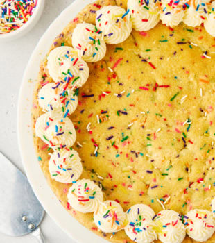 overhead view of sugar cookie cake on a white cake stand